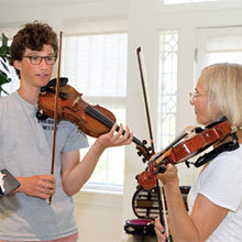 Intern instructor Sam Panner, left, with a violin student.