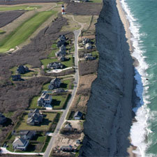 This 2011 aerial photo shows the sheer face of the eroded Sconset Bluff along Baxter Road, with the relocated Sankaty Light toward the top.
