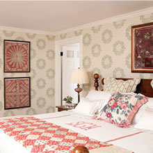 The master bedroom is furnished with early American furniture and the soft pink and sage green used throughout the house are found here. Checks, florals and geometric patterns are characteristic of the period of the house.