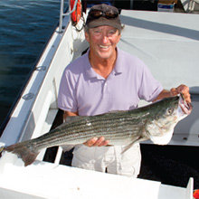 Althea K charter-boat captain Pete Kaizer with a striped bass.