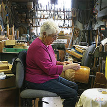 Susan Ottison weaves a basket in her workshop. Susan and her husband Karl have been practicing the craft of lightship basket making since 1968.
