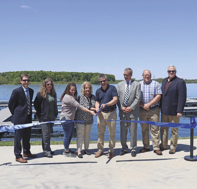 A ribbon cutting for Waddington’s new docks with a capacity for up to 64 vessels was held Friday, May 26. From left: NYPA Regional Manager of NNY Bryant Bullard, Director of Division of Planning for Dept. of State Stephanie Wojtowicz, Waddington Village Board Trustee Olivia Martin, past mayor Janet Otto-Cassada, Mayor Mike Zagrobelny,  Assemblyman Scott Gray, Deputy Town Supervisor Travis McKnight, and Senator Daniel Stec. NCNow photo by Cheryl Shumway
