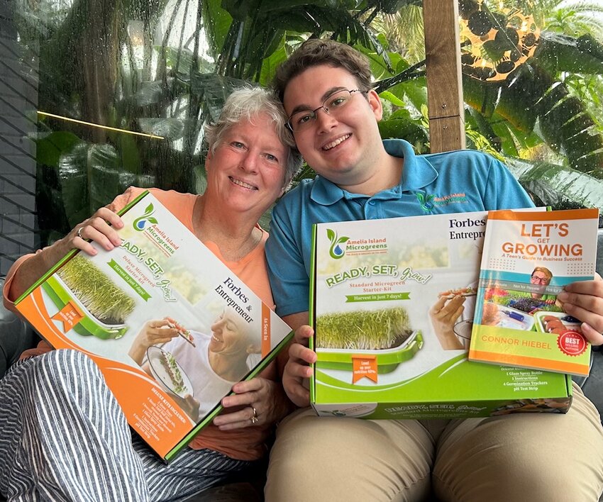 Connor and his mom, Christine, hold Connor's book and microgreen kit.