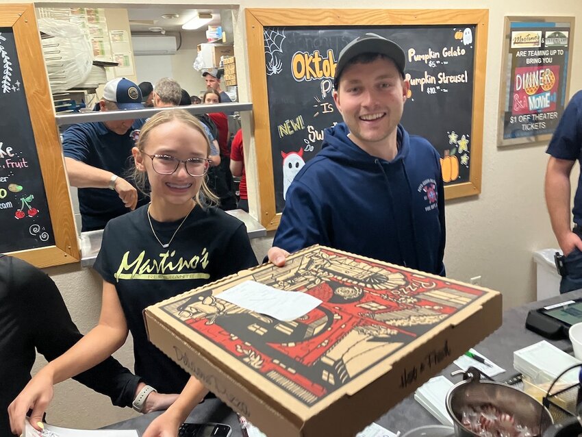 Taylor Summerfield (left) and Ryan Eslinger help out during Saturday’s Pizza and Fire Prevention fundraiser at Martino’s.