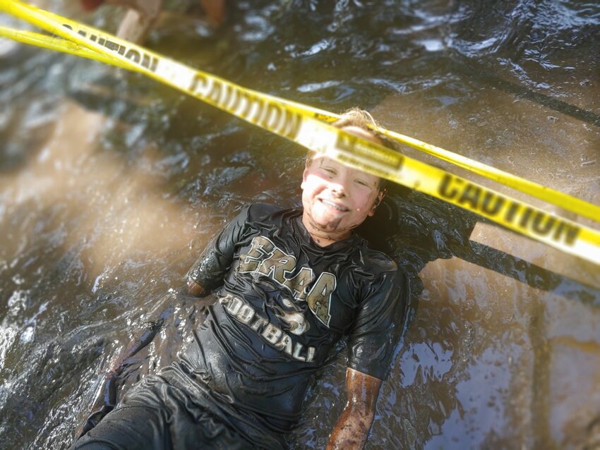 A participant enjoys getting dirty at the Kids Adventure Mud Run