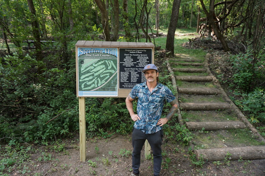 Course designer and organizer Andrew P. Reese standing in front of the Sterling Hill Disc Golf Course map in River Falls.