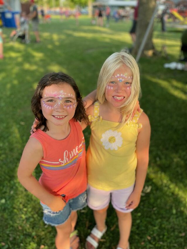 Lydia Peterson (left) and Hannah Hazuga (right) are all smiles after their free face painting from The Cheek Boutique.