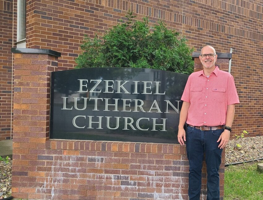 New Ezekiel Lutheran Church Pastor Steve Dow standing in front of the church&rsquo;s sign in River Falls.