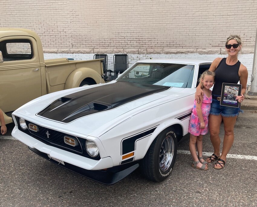 Heather Junker (right) with the Mach One that won People's Choice at the 3rd annual Reclaimed Car Show. Beside her is her daughter Vivian.
