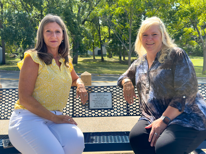 Kris Milliren (L) and Lori Hanson-Braun were on hand to witness the installation of the Class of 1988&rsquo;s memorial plaque on a bench overlooking the Mississippi River along Lock and Dam Road.