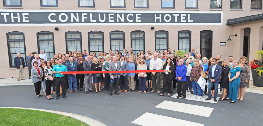 Pat Regan of Confluence Development, LLC cut the ribbon to officially open The Confluence in downtown Hastings on Thursday. Regan was surrounded by members of the development team, city officials, business owners and community members who turned out to celebrate the occasion.