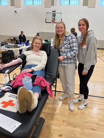 Grace Anderson, Spring Valley ag teacher, donates blood. She is pictured with NHS students Maddie Shafer and Charli Vanasse, who worked at the drive.