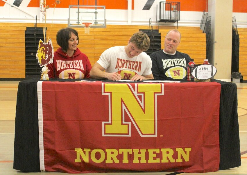 Chase Sturm (center) signs intent to play football at Northern State University this past Thursday, as mom Erica and dad Nick look on.