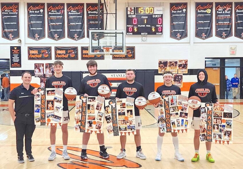 Shown above at Senior Night against McDonell, each member of the boys varsity received a photo montage and custom made basketball with their picture. From left to right are Coach Dakota Nichols, Henry Hoel, Riley Weltzin, J. J. Heller, Landon Karlen, and Haydn Gustafson.