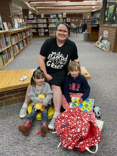 Kindergarten student Dayna Oberholtzer read with her mom and sister.