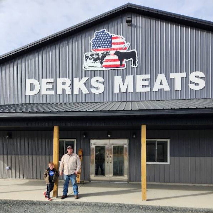 Matt Derks (right) and his son, Jonathan, stand proudly in front of the new Derks Meat sign installed by Ron’s Designs & Signs.