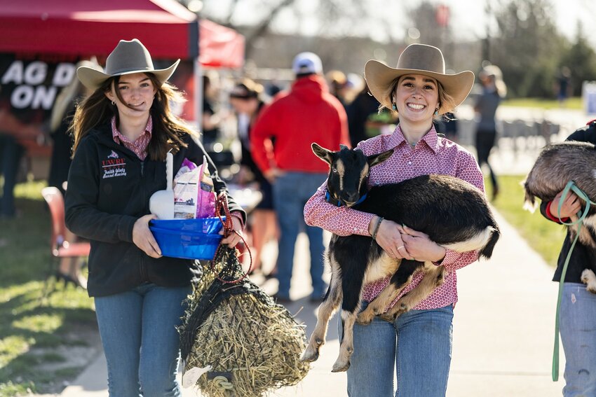 Scout Emery, right, the 2024 UW-River Falls Queen of the Rodeo, and Faith Watz, left, carry a baby goat and supplies at the start of UWRF&rsquo;s Ag Day on Campus. The UWRF Collegiate Farm Bureau Chapter annually hosts Ag Day on Campus, which began in 2012. This year&rsquo;s theme was &ldquo;Growing for Generations.&rdquo; The event included numerous informational booths, fun contests and more throughout the day on the campus mall. It concluded with a free evening meal in the Agricultural Science building and a panel discussion in the University Center about the future of agriculture.