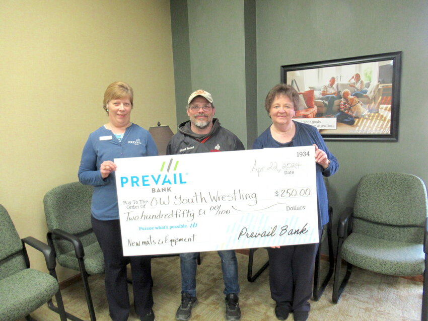 Wrestling Coach, Phil Goessl (center), accepted the $250 check from Prevail Bank professionals Sue Struensee, Universal Banker, and Linda Susa, Branch Manger.