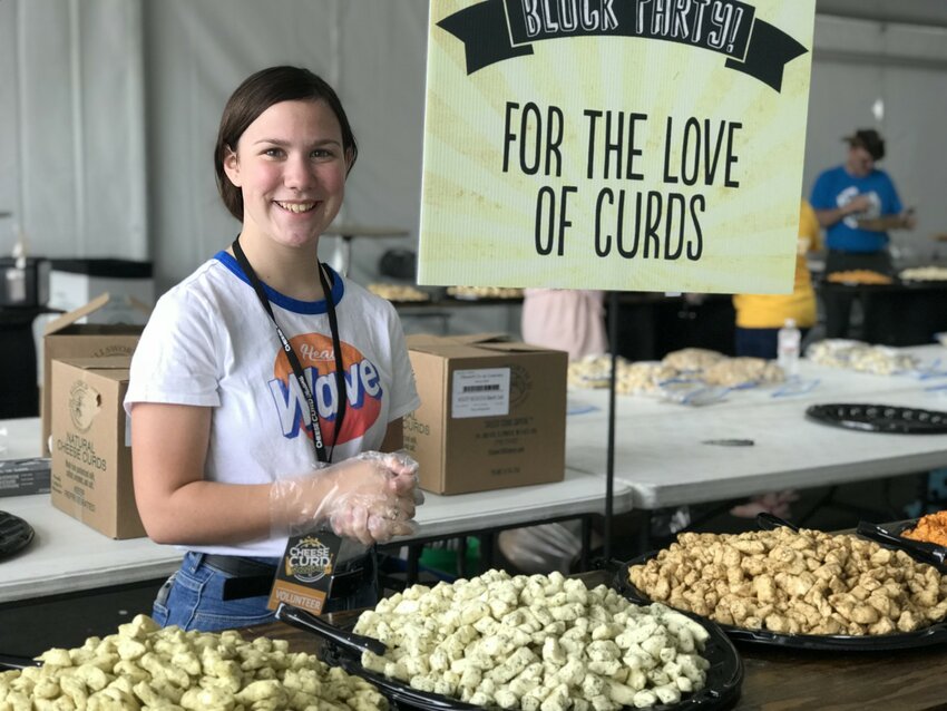 Audrey Farrell serves up fresh curds to festival guests at the Wisconsin Block Party tasting event during the Cheese Curd Festival.
