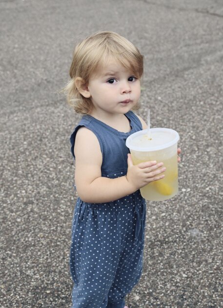 Shea Murphy, age 2, enjoyed a refreshing glass of tart lemonade at the 2024 Cheese Curd Festival.