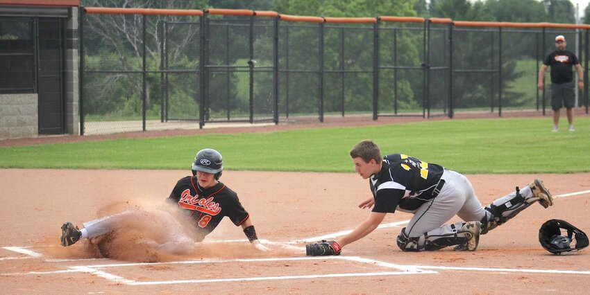 Landon Ewer slides into home during Thursday’s game against Cadott as coach Jake Tiry looks on.