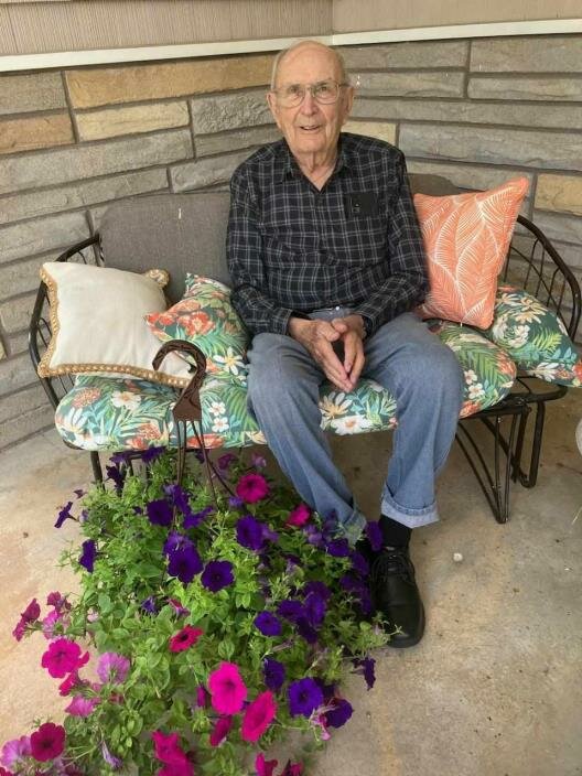 Norby Pabich, 2024 Owen-Withee Golden Blackhawk award recipient at his home in Owen in July 2024, with a basket of flowers presented to him and his family, courtesy of the Owen-Withee Area Historical Society and the Frenchtown Greenhouse.