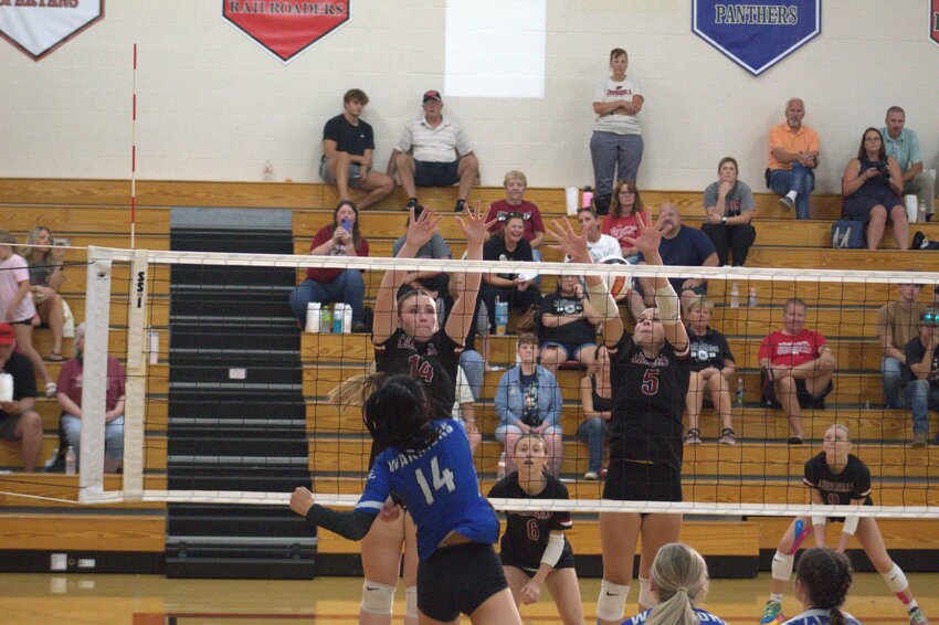 Addison Neidermyer and Evah Butts attempt a block during a win over Clear Lake at the Baldwin-Woodville quad Sept. 12.