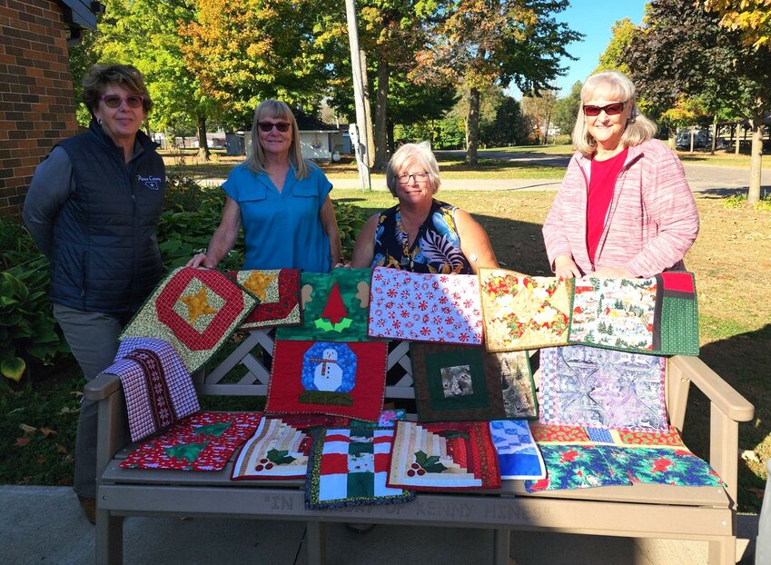 Pictured (from left) with a display of the Placemat Challenge quilted placemats are Fair Manager Liz Dietsche, quilter Julie Peterson, Pierce County Nutrition Coordinator Lena Aumann and Pierce County Fair Open Class Home Furnishings Superintendent Marsha Shafer.