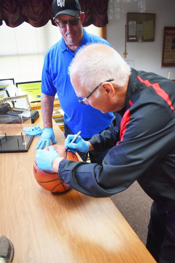 - Former Girls Basketball coach Al Guthman stopped by the O-W Area History Center on October 2 to sign the basketball which will hold the signatures of the 1984 Championship team. OWAHS Vice-President Tim Nolan (also pictured) help organize the donation.