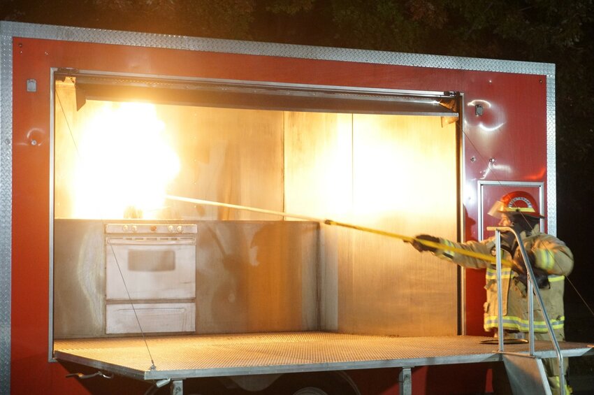 Firefighter Wargo demonstrates why not to put water on a grease fire at the Hastings Fire Department open house.