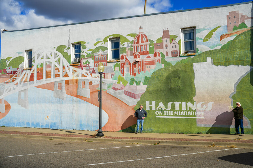 The full mural upon completion in 1998 (left) was vibrant and beautiful. That beauty did last but many of the details and the bountiful colors faded as time went on. The 2024 picture (right) gives a perfect example of why it is time to replace the mural. 1998 photo submitted, 2024 photo by Bruce Karnick