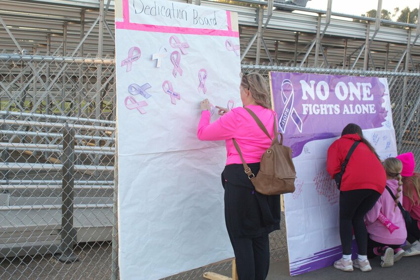 Prescott fans put names on the dedication board that are battling or survived cancer during the Tackle Cancer event from Prescott Football.
