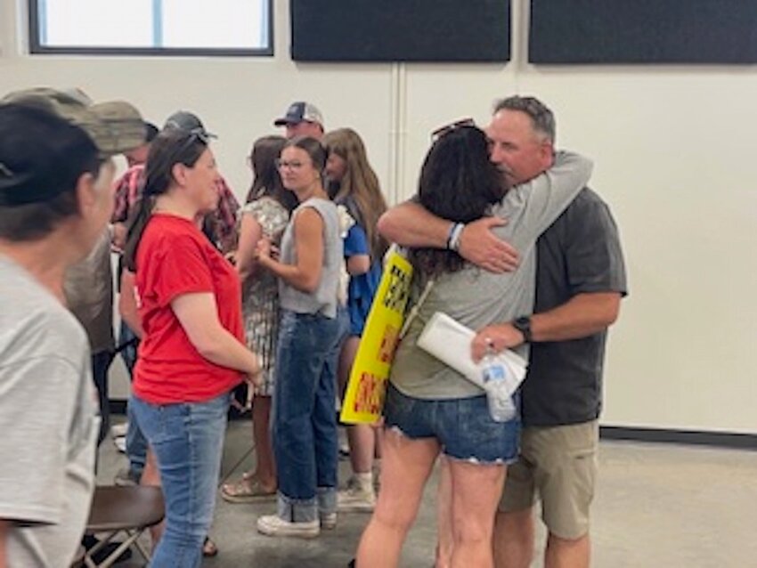 John Hoel (center) was met with congratulations, handshakes, and heartfelt hugs from supporters, who expressed their relief and appreciation following the meeting.