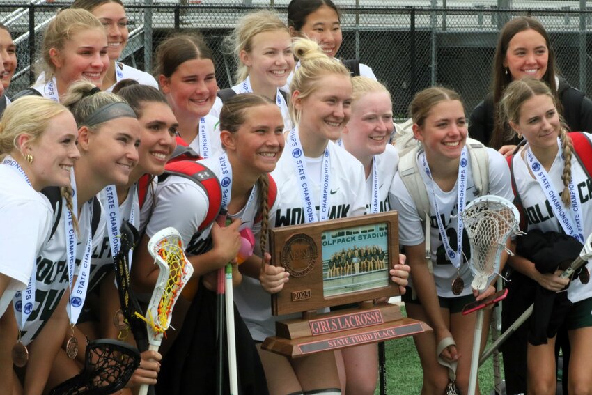The Wolfpack are all smiles as they pose for photos with their state tournament trophy.