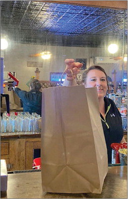 Alex Rinehart of Kelly Grill smiles as she hands out an order at the restaurant on First Avenue in Stanley recently. Photo by Joseph Back.