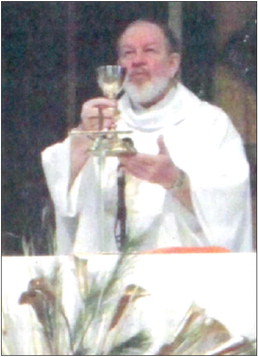 Father Robert Nelson raises the chalice at his farewell Mass in January 2010. Photo by Daniel Williams.