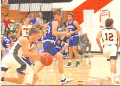Lucas Smith drives the ball downcourt against St. Croix Central, as elsewhere Carsen Hause and Landon Karlen keep an eye on the competition. Photo by Joseph Back.