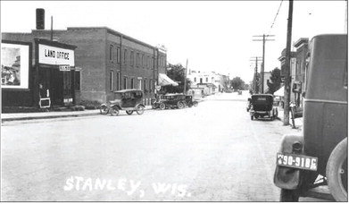 The newspaper received the above picture from David Jankoski, showing a town scene from what appears to be around 1920. Several buildings may be familar to readers, but what’s in the far distance on the left, just in front of Stanley House? The point in question is now home to Kwik Trip.