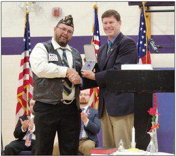 Bay City American Legion Adjutant and retired Army Reserve combat veteran Devin Feuerhelm (left) received a Purple Heart from U.S. Rep. Ron Kind Friday, Nov. 11 at Ellsworth Middle School’s Veterans Day ceremony. Photo by Sarah Nigbor