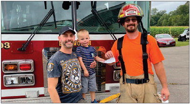 Jason &amp; Polly Marks, owners of Broz Bar in Ellsworth, recently donated $250 to the Ellsworth Fire Department. Pictured are (from left) Jason Marks, his son Cash and firefighter Mike Allyn. Photo courtesy of Polly Marks