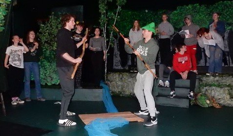 Little John, played by Caleb Bartko, battles with Robin Hood, played by R.J. Hybben, for the right to cross the stream as the crowd watches.