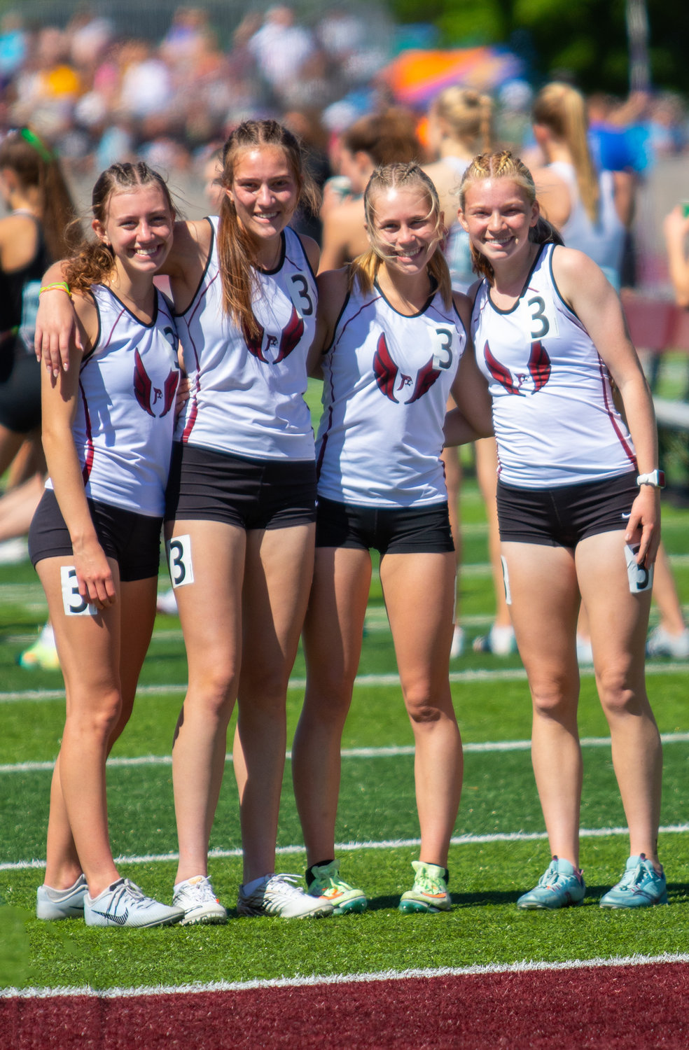 The Prescott Lady Cardinals’ 4x800-meter relay group of (from left) Ava Budworth, Sophie Ripley, Maddie Matzek and Ella Johnson enjoy a moment together on the first day of competition at the state championships in La Crosse last season.