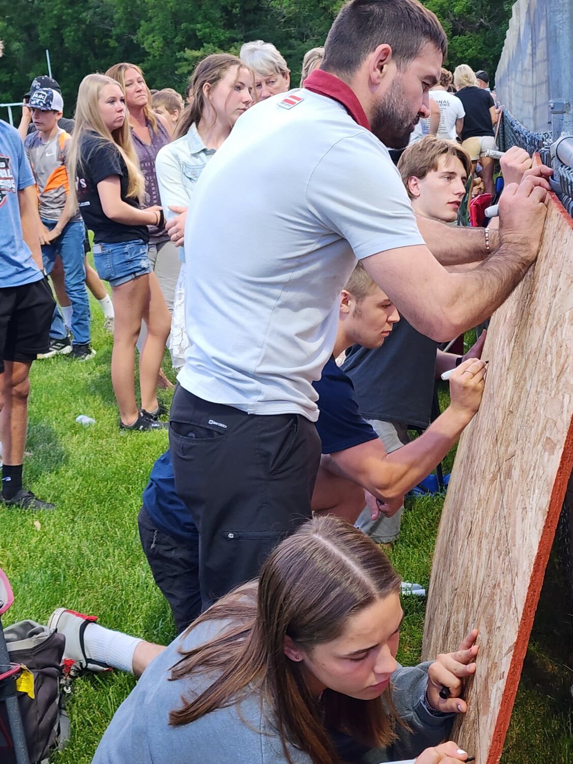 People lined up Wednesday, May 31 to sign prayer boards for the Bleskacek and Loga families at the Elmwood football field.