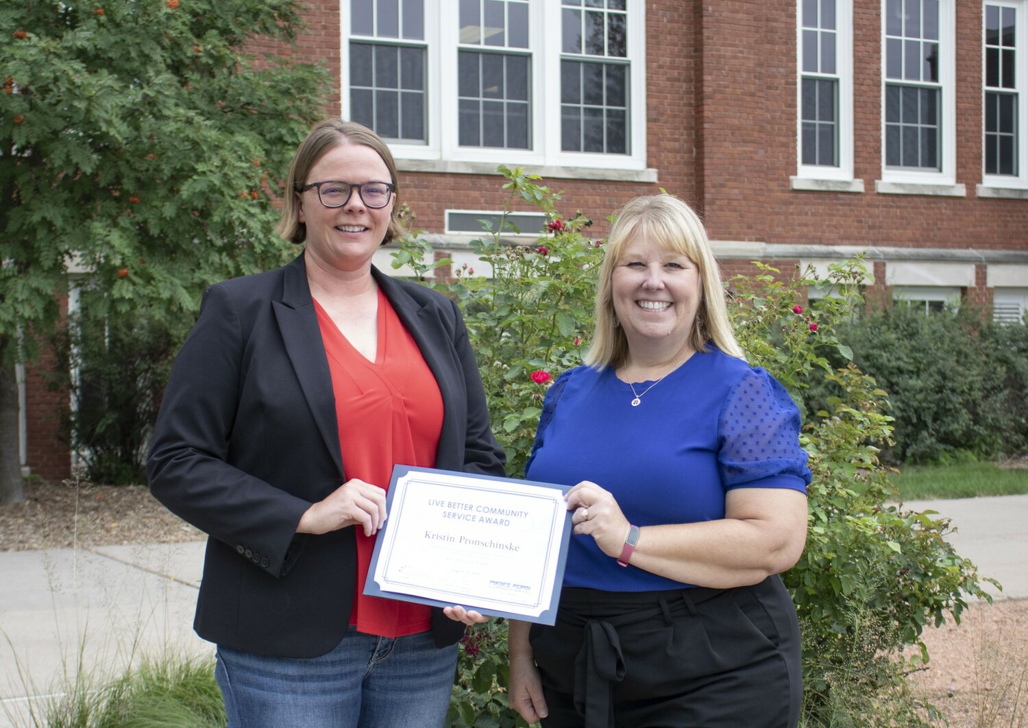 Kristin Pronschinske (left) received the Live Better Community Service Award from Charity Lubich, PPCS vice president of member services and human relations. The award included a certificate of recognition and a $100 MasterCard gift card.