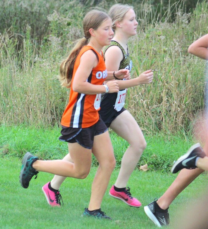 Above, Lucy Wundrow runs at Thorp, making Honorable Mention All Conference for the season.