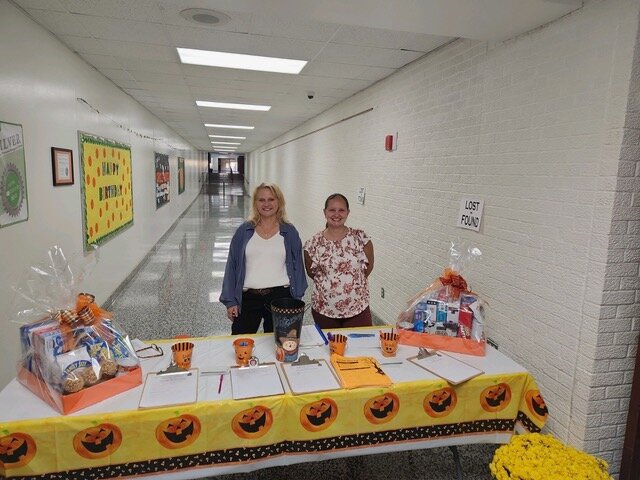 Lisa Eslinger (left) and Terri Roscoe (right) greeted and directed students and their families as they chose a free book before heading to the Stanley-Boyd Elementary Gym.