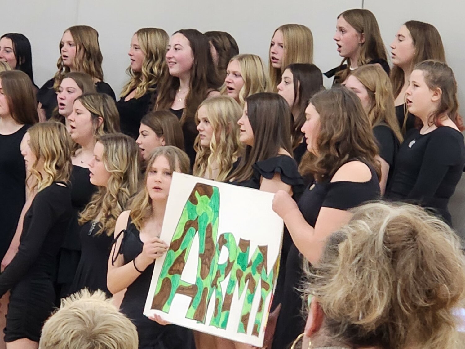 Eighth grade choir students hold an “Army” during “A Tribute to the Armed Services,” asking those who had served in the Army to stand up for recognition Friday, Nov. 10.