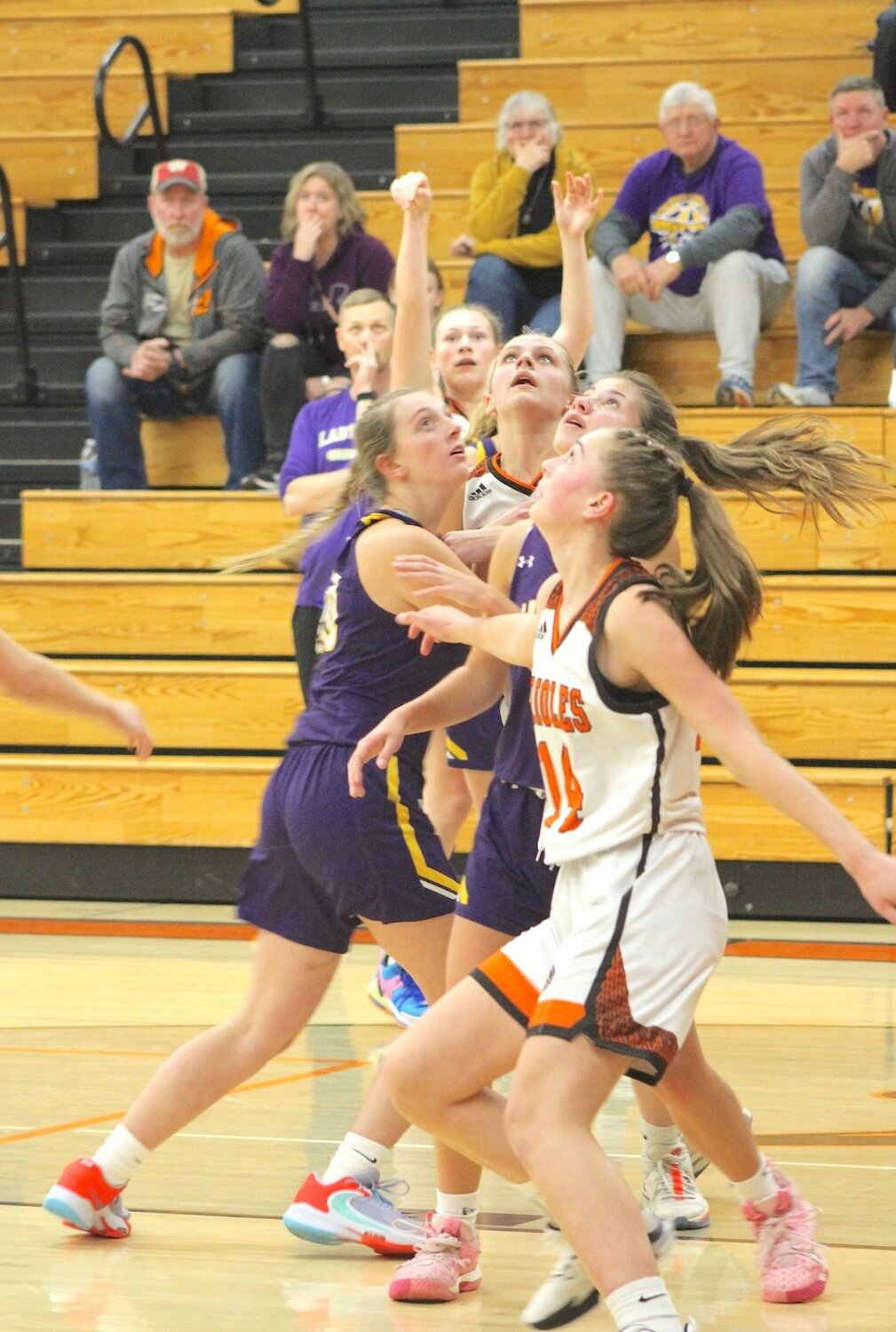 Bailey Sikora (background) makes a three point shot as teammates Syleen Seichter (middle) and Aliyah Allard (front) await the rebound Nov. 21 at home.