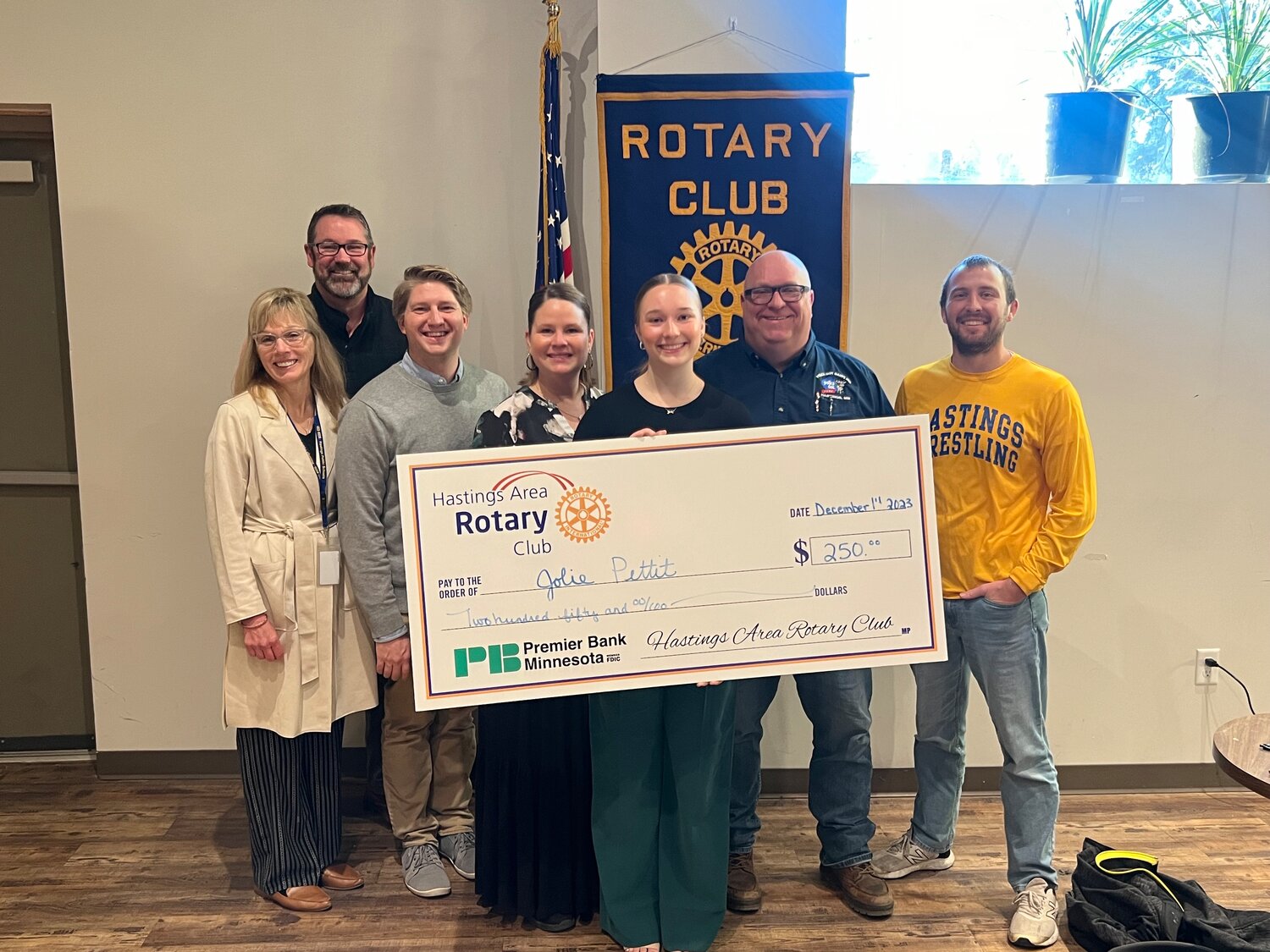 Jolie Pettit was honored as the November Hastings Rotary Club Student of the month. Pettit is pictured holding the check, flanked by her parents, Jessica and Joe and Hastings Schools staff members (from left) Superintendent Dr. Tamara Champa, High School Principal Scott Dorn, French teacher Anthony Letourneau and Hastings wrestling coach Tim Haneberg.