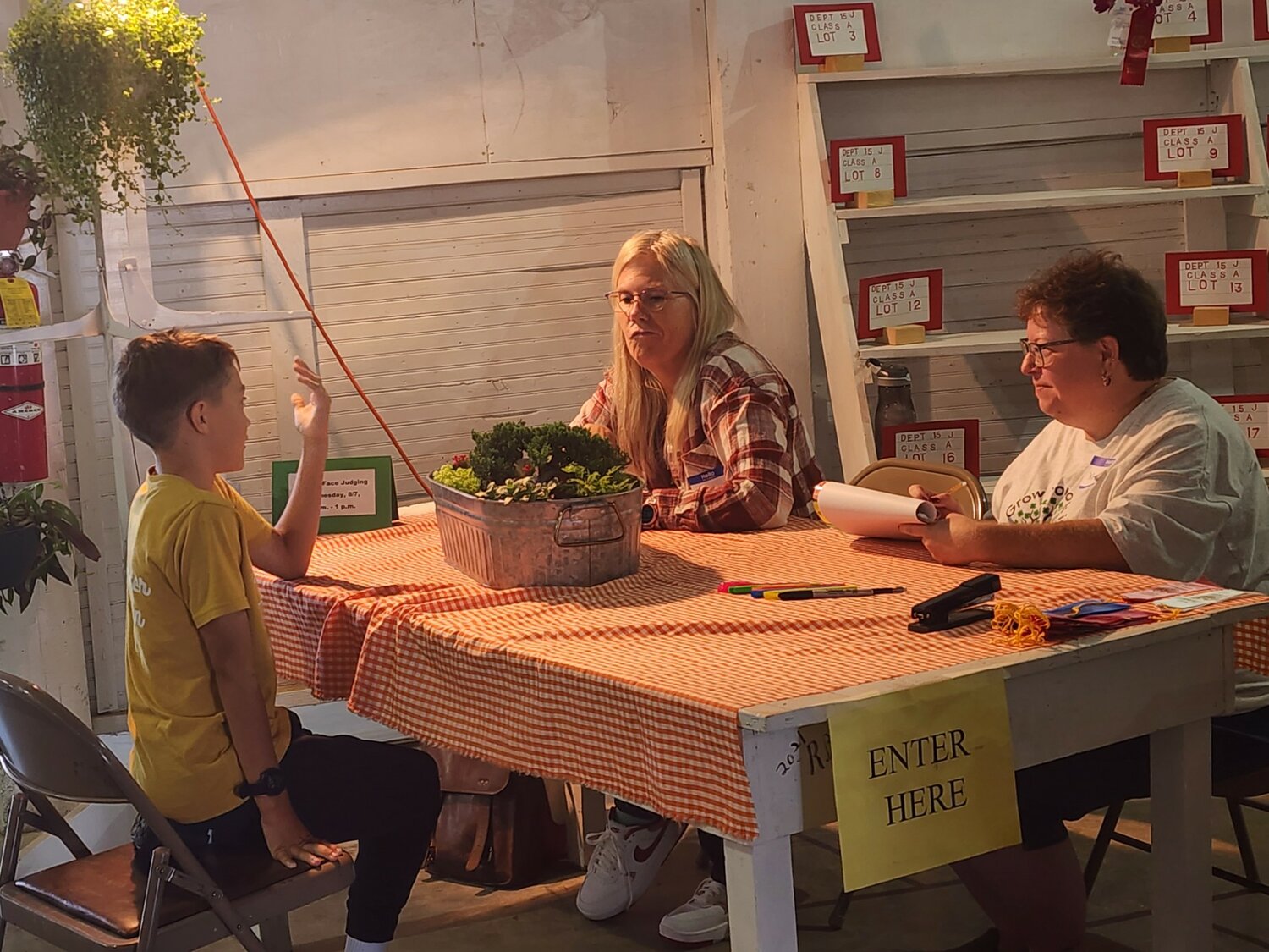 Junior Fair Flowers & Houseplants Superintendent Krista Klecker oversees the judge and an entrant during judging on Wednesday, Aug. 7.